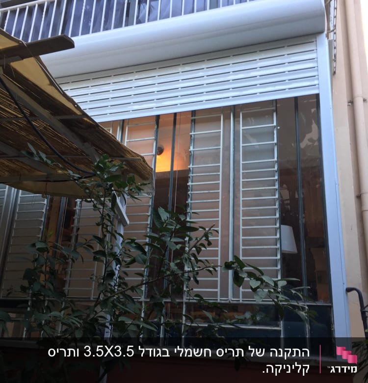 תריסי אלומיניום לבנים על חלון זכוכית